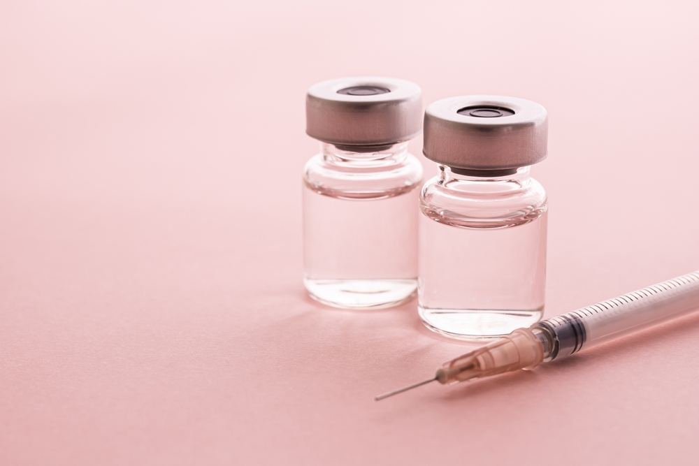 Syringe and vial of compounded semaglutide on pink background