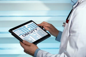 A GLP-1 provider holding a tablet that says "Obesity"