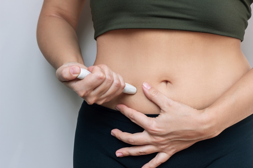 Person injecting themselves with GLP-1 Semaglutide in the stomach for weight loss