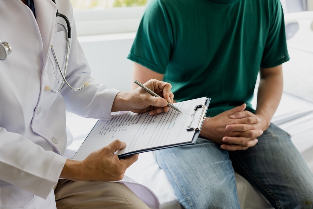 Healthcare provider reviewing treatment documentation and intake forms with a patient